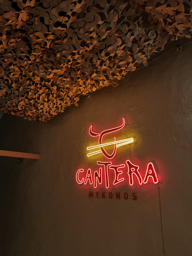 Insegne neon personalizzate accese nella vetrina di un locale serale